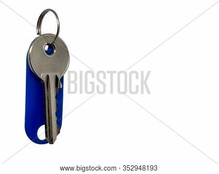 Single Key And A Blue Key Ring With Tag On White Background.
