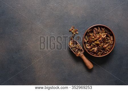 Beautiful Raisins In A Plate On A Dark Concrete Background With Place For Text. View From Above.