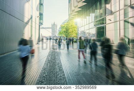 business people, modern buildings and Tower Bridge, London, UK