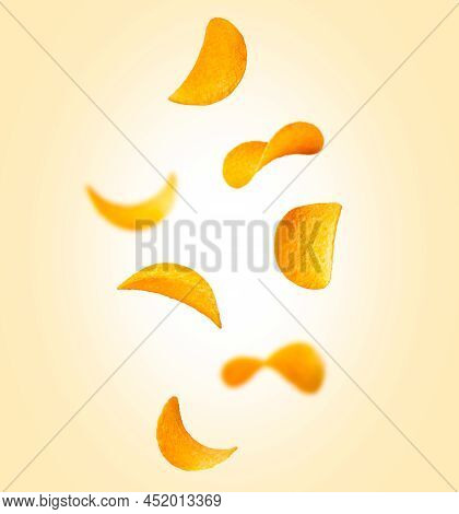 Potato Chips Are Falling On A Orange Background. Levitation