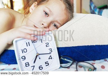 Girl Sleeping On A Pillow With An Alarm Clock In Hand Resting In The Morning