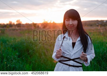 Young Woman In Baldric On The Summer Field On Sunset Or Sunrise. Peaceful Calm Female. Trendy Clothe