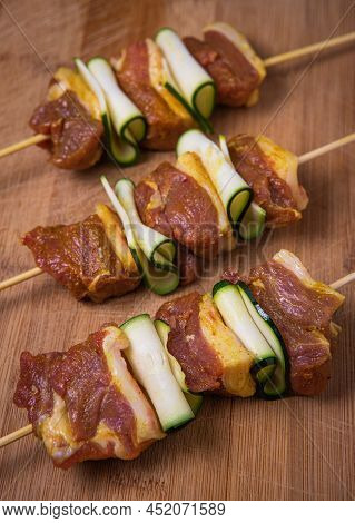 Raw Lamb Skewers With Zucchini Slices On Wood High Quality Photo