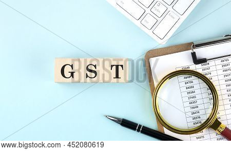 Gst Word On Wooden Cubes On A Blue Background With Chart And Keyboard