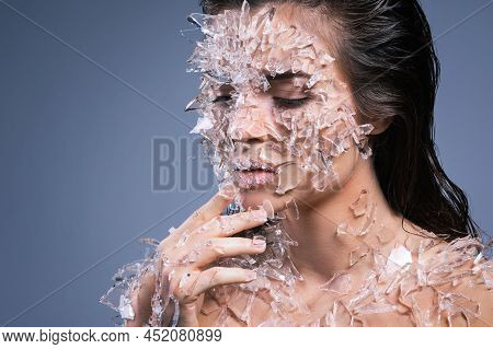 Female Face Covered With A Lot Small Pieces Of Glass Or Ice