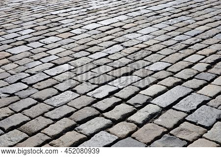 Stone Pavement Texture, Cobbled Street In Sunlight. Old Paved Road With Tiles From Cobblestones