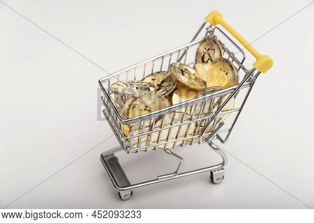 Side View Of Bitcoin And Shopping Cart On White Background. Buying Or Selling The Cryptocurrency Con