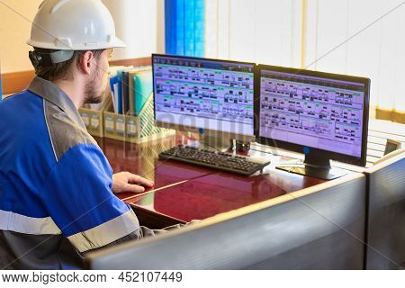 Worker In Overalls Uses A Linear Telemechanics System To Control The Technological Processes Of The 
