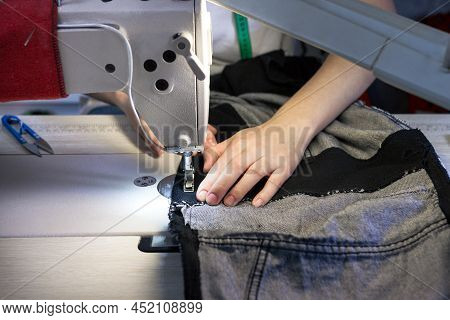 Hands Of A Seamstress Working For The Machine .close Up.