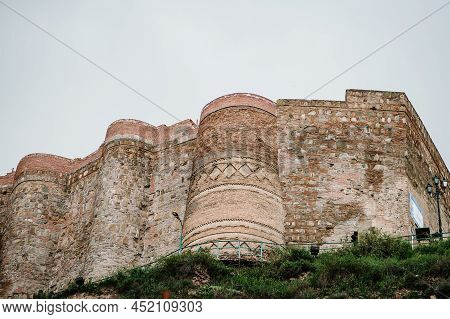 Old City Wall From Stones With Towers Round A City, Ancient Fortress Narikala In The Old Town Of Tbi