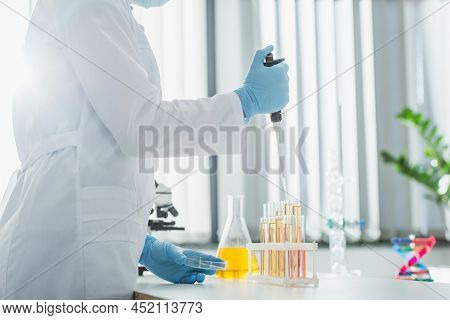 Partial View Of Geneticist In White Coat Working With Micropipette And Test Tubes.