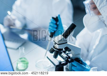 Selective Focus Of Microscope Near Blurred Bioengineer With Micropipette In Lab.
