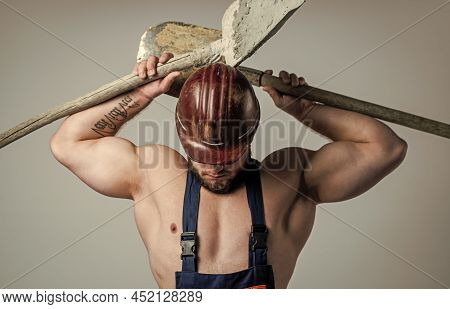 Professional Skills. Labor Day. Athletic Guy Wear Safety Helmet. Male Engineer On Work With Shovel. 