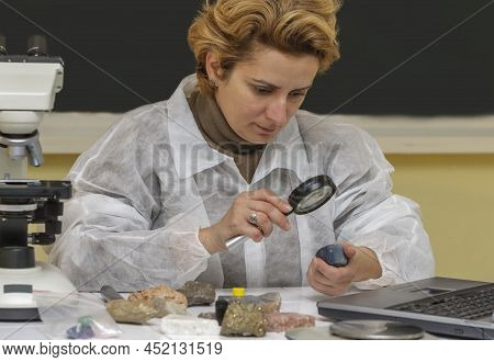 Female Geologist Researcher Analysing A Rock At Her Workplace.