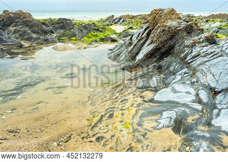 Tidal Rock Pool Surrounded By Smooth Rocks And Seaweed,dollar Cove,gunwalloe, Helston,cornwall,engla