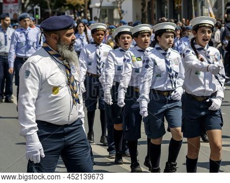 Limassol, Cyprus, March 25th, 2022: Boy And Girl Scout Group With Adult Leader Marching Along Archbi