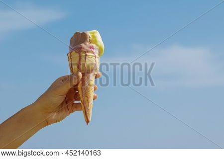 Jand With An Ice Cream Cone And Blue Sky