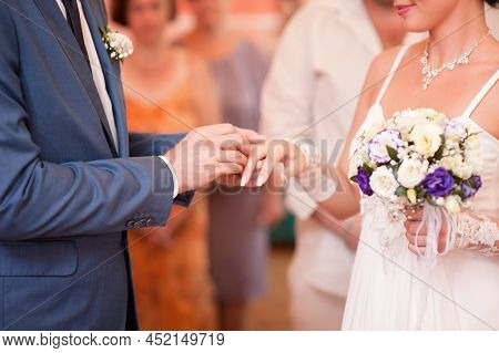 Wedding Ceremony. Groom Putting Golden Ring On Bride's Finger Closeup. Wedding Rings Exchange Vows.
