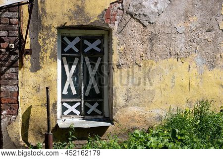 A Shabby, Rough, Cracked Wall, Taped Windows. The Concept Of The Devastation Of War, Poverty