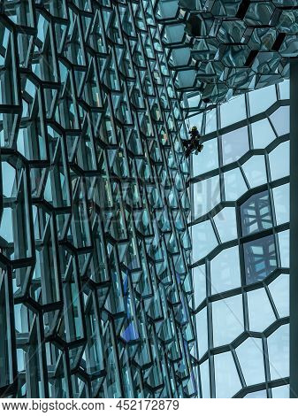 Reykjavik, Iceland - March 23, 2022: A Steeplejack Cleaning Windows Inside Harpa Concert Hall. Moder