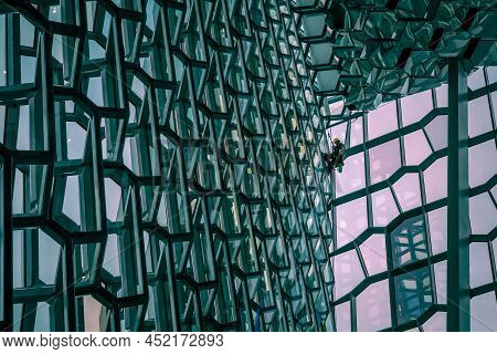 Reykjavik, Iceland - March 23, 2022: A Steeplejack Cleaning Windows Inside Harpa Concert Hall. Moder