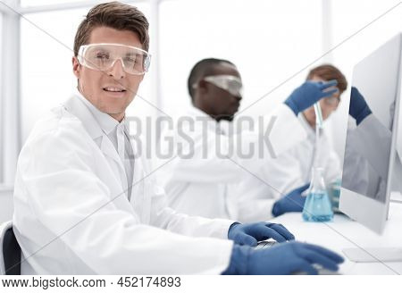 modern scientist sitting in front of a computer monito