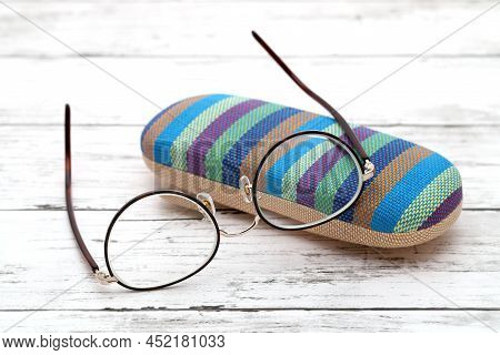 Stylish Eyesight Glasses And Case For Glasses On White Wooden Table