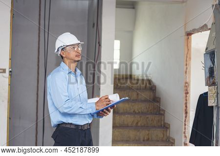 Man Construction Engineer Writing Note Wear Blue Shirt Safety White Hard Hat At Construction Site. I