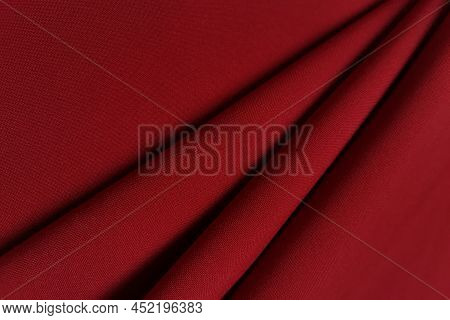 Red Crumpled Or Wavy Fabric Texture Background. Abstract Linen Cloth Soft Waves. Gabardine Wool Fabr