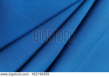 Blue Crumpled Or Wavy Fabric Texture Background. Abstract Linen Cloth Soft Waves. Gabardine Wool Fab