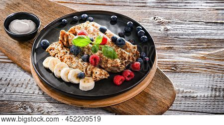 A Plate Of Pancakes With Cheese And Fruits