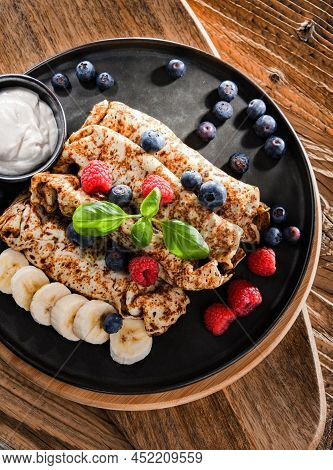 A Plate Of Pancakes With Cheese And Fruits