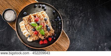 A Plate Of Pancakes With Cheese And Fruits