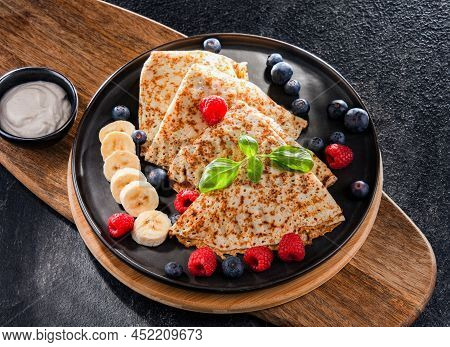 A Plate Of Pancakes With Cheese And Fruits