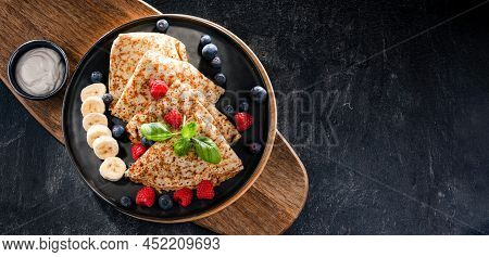 A Plate Of Pancakes With Cheese And Fruits
