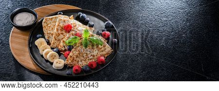 A Plate Of Pancakes With Cheese And Fruits