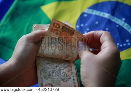 Brazilian Money Next To A Flag