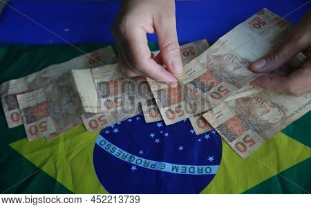 Brazilian Money Next To A Flag