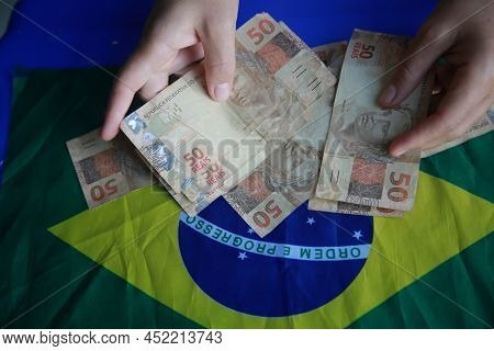 Brazilian Money Next To A Flag