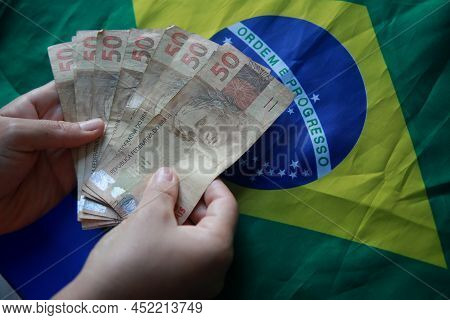 Brazilian Money Next To A Flag