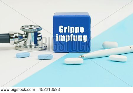 Medical Concept. On A White And Blue Surface Are Pills, A Stethoscope, A Pen And A Cube With The Ins