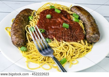 Spaghetti And Sweet Italian Sausage Served With Sauce And Green Onions,