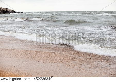 Huge Waves Raging In The Sea And Seagulls In The Spray Of Waves. Storm At Sea. Birds Fly Over The Wa
