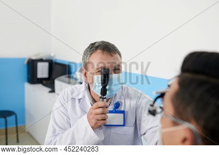 Experienced Ophthalmologist Using Retinoscopy Tool When Examining Patient Before Vision Correction S