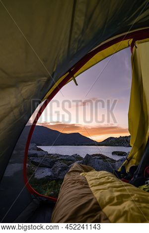 Person Inside A Sleeping Bag With Feet Outside The Tent