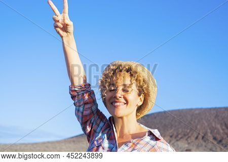 Victory Hand Gesture To Stop War And Love Peace For People Concept Image With Happy Adult Woman In T