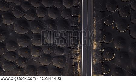 Volcanic Ground Aerial Drone View With Vineyards And Long Straight Asphalt Road. Travel In Scenic Pl