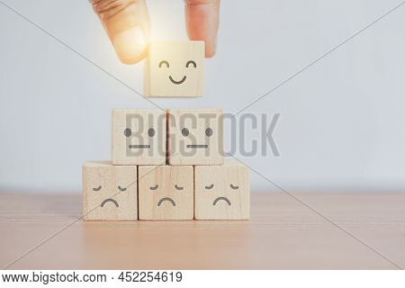 Businessman's Hand Show Feedback With Smiling Face Wooden Cube Blocks, Happy Smile Face Icon To Give