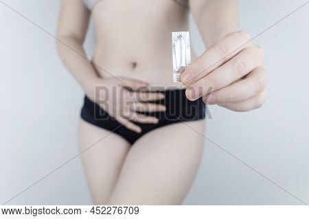 Vaginal Or Rectal Candle In The Hands Of A Woman Against The Background Of The Abdomen And Underwear