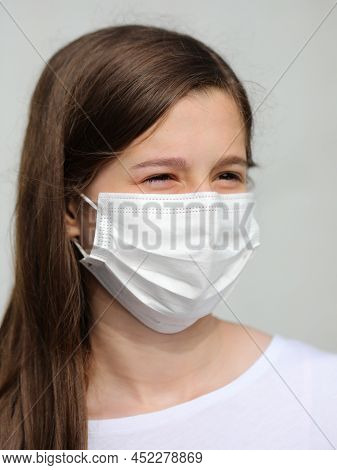 Beautiful Girl With Long Brown Hair And Smiling Eyes With White Mask To Protect Herself From Coronav